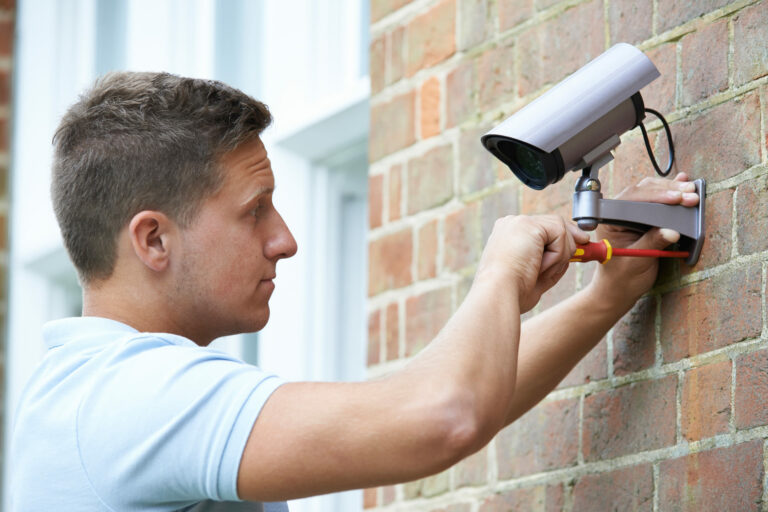 Security Camera System Installer putting camera on side of home